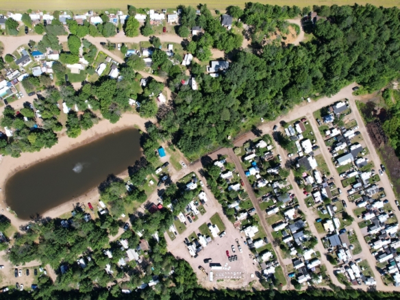 Photo aérienne de camping à vendre avec lac privé, plage de sable, terrains boisés et emplacements pour roulottes et VR au Québec