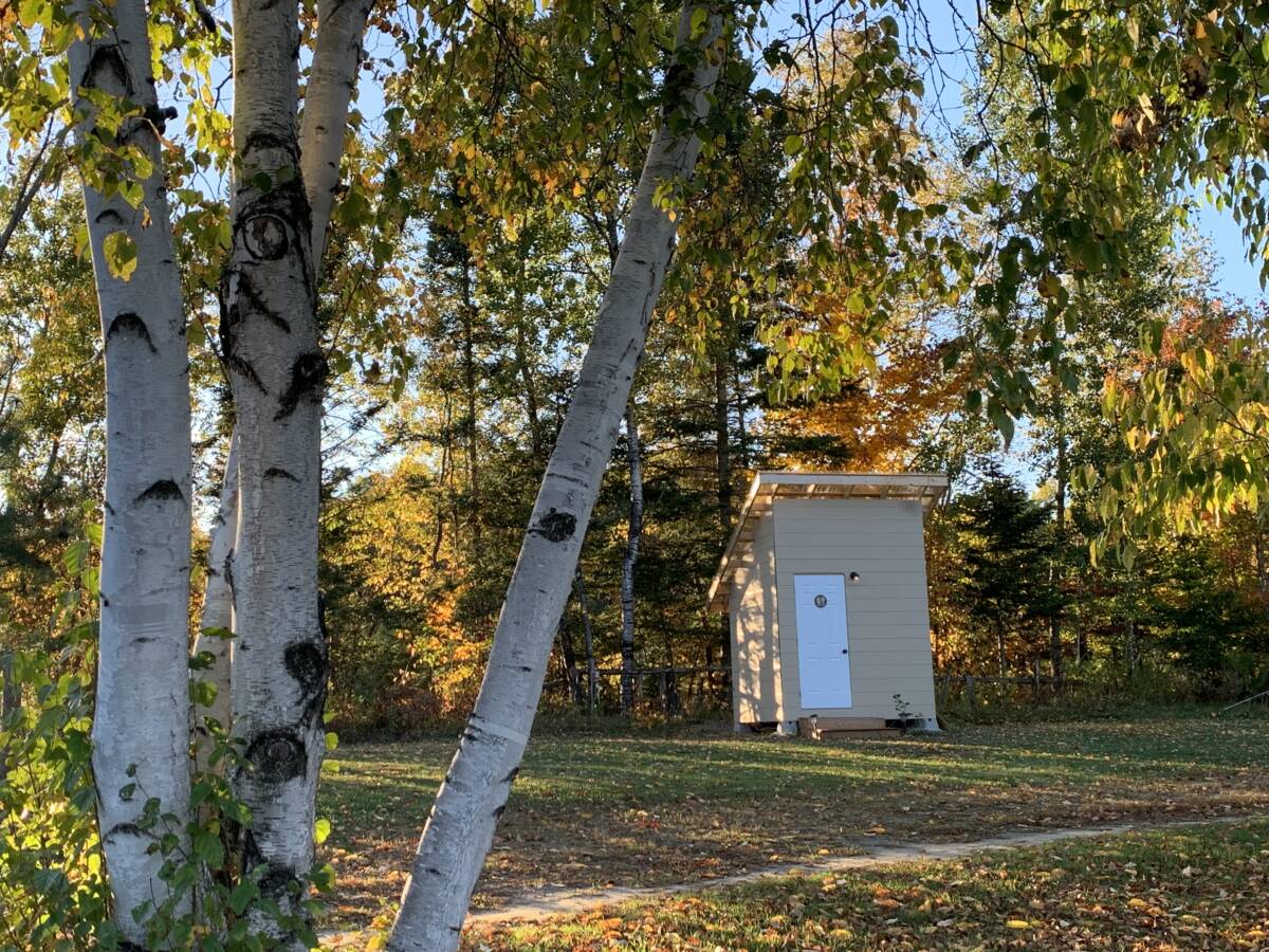 Installations sanitaires du domaine de glamping – Mont-Tremblant Petit bâtiment de bloc sanitaire moderne situé en lisière de forêt sur un domaine de glamping à vendre près de Mont-Tremblant.